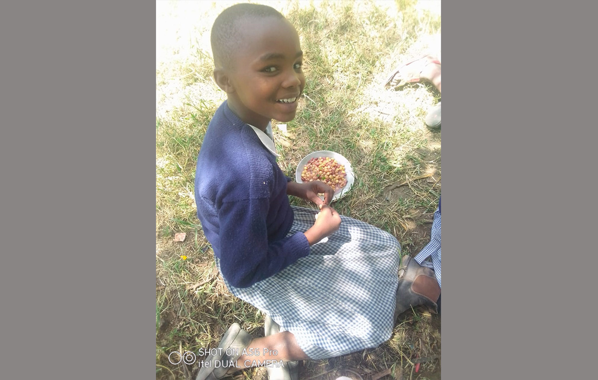 Happy child enjoying her plate of githeri